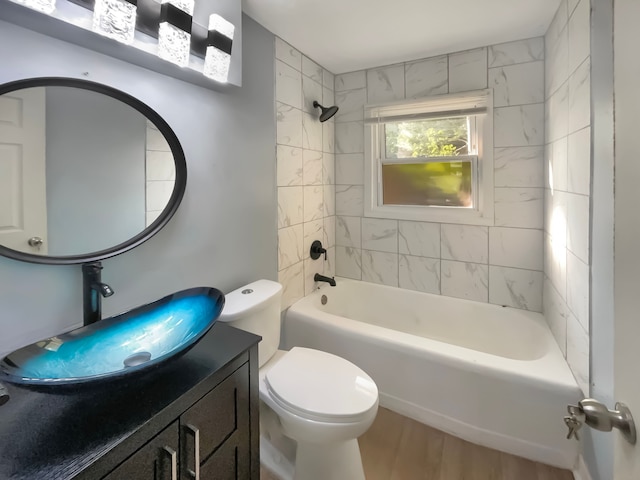 full bathroom with vanity, toilet, tiled shower / bath, and hardwood / wood-style flooring