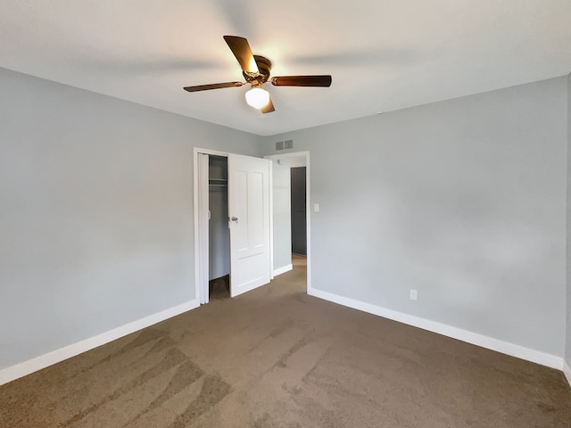 unfurnished bedroom with a closet, dark carpet, and ceiling fan