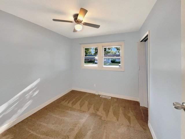 empty room with ceiling fan and carpet floors