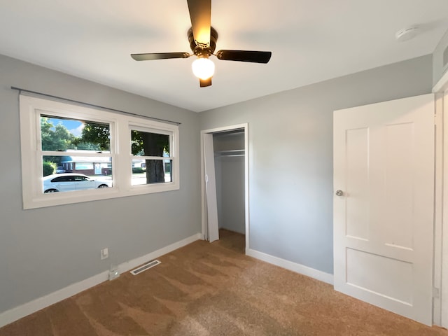 unfurnished bedroom with ceiling fan, carpet floors, and a closet