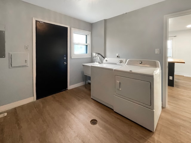 laundry room featuring sink, washer and dryer, and light wood-type flooring