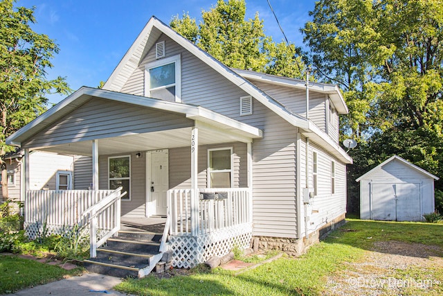 bungalow-style home featuring a porch and a storage unit