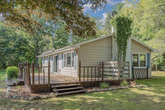 back of house with a deck and a yard