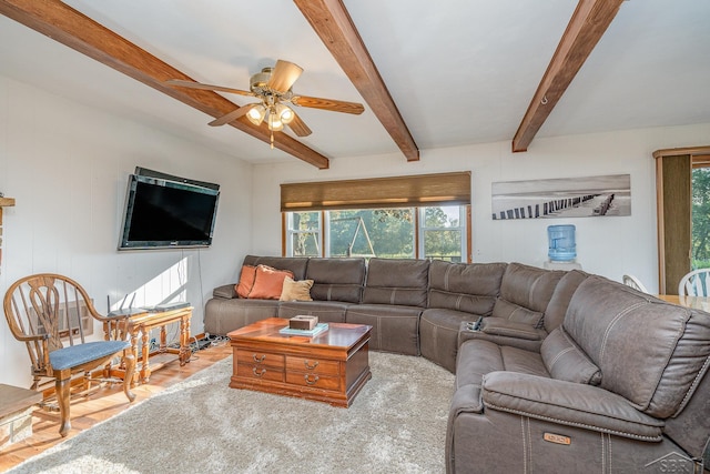 living room featuring beam ceiling, light wood-type flooring, plenty of natural light, and ceiling fan