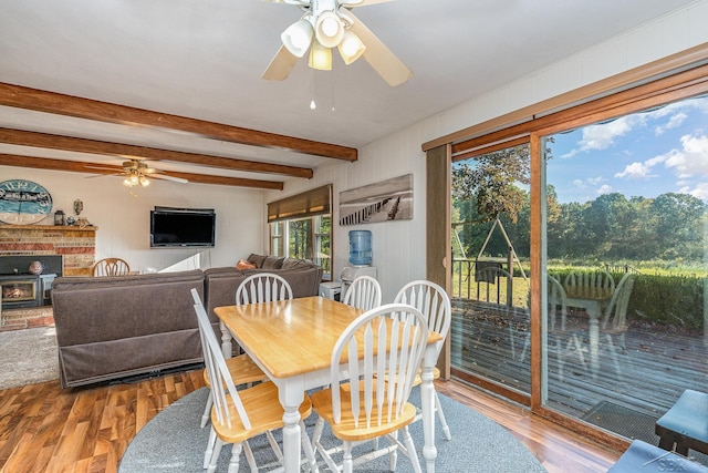 dining space featuring hardwood / wood-style flooring, plenty of natural light, beam ceiling, and ceiling fan