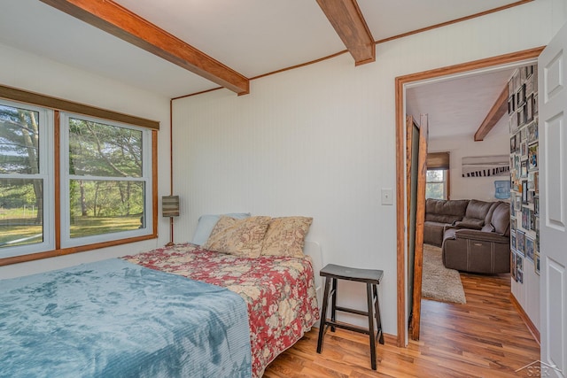 bedroom with beam ceiling and wood-type flooring