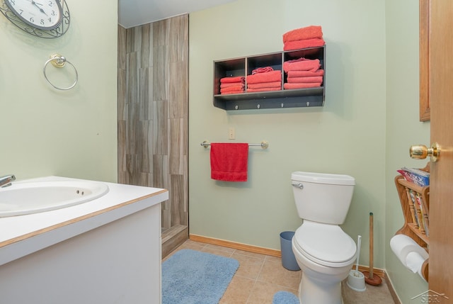 bathroom with tile patterned flooring, vanity, tiled shower, and toilet