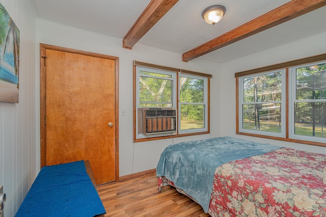 bedroom with beamed ceiling, light hardwood / wood-style flooring, cooling unit, and wood walls