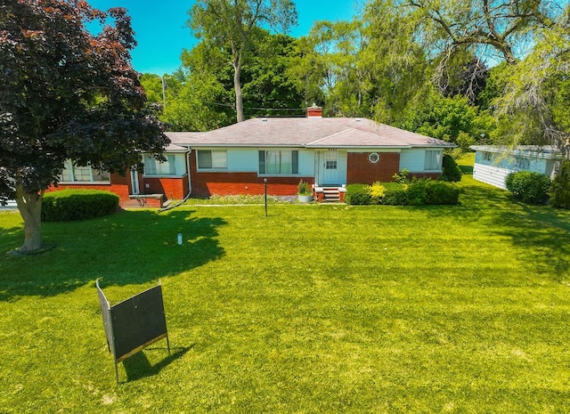 1023 Turrill Rd, Lapeer, MI 48446 - rear view of property featuring brick siding, a yard, and a chimney