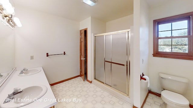 bathroom with toilet, an enclosed shower, and vanity