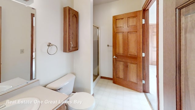 bathroom featuring toilet, vanity, and walk in shower