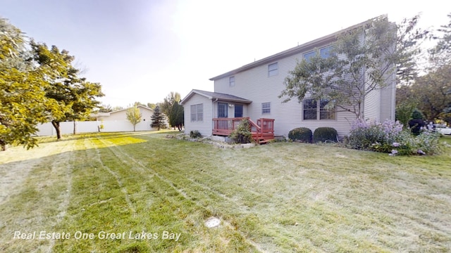 back of property featuring a wooden deck and a lawn