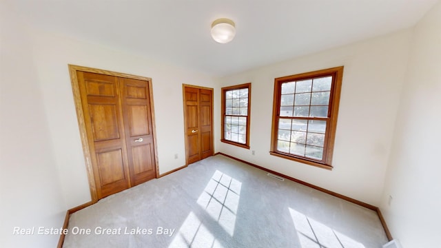 unfurnished bedroom featuring light carpet