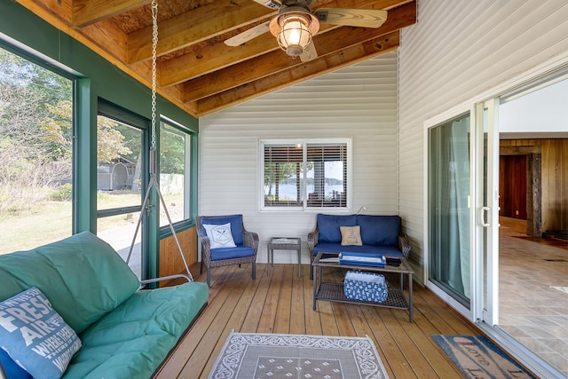 sunroom / solarium featuring a wealth of natural light, ceiling fan, lofted ceiling with beams, and wooden ceiling