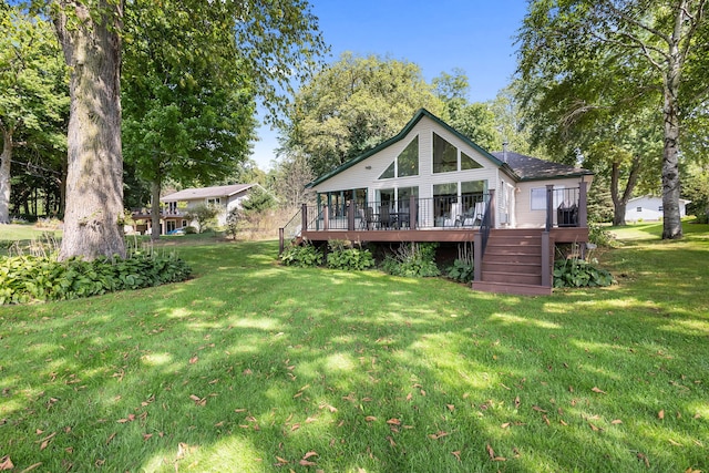 back of property with a lawn and a wooden deck