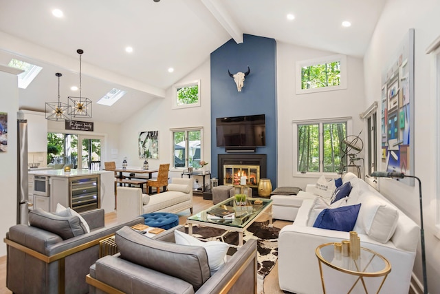 living room with beverage cooler, light hardwood / wood-style flooring, high vaulted ceiling, beamed ceiling, and a chandelier