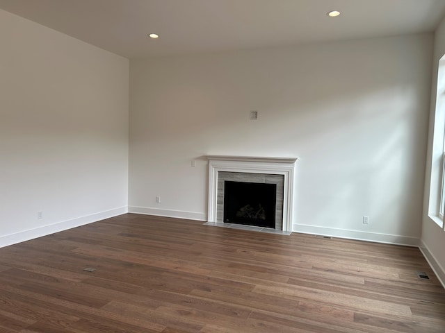 unfurnished living room featuring a fireplace and dark hardwood / wood-style flooring