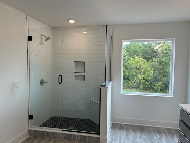 bathroom with plenty of natural light, vanity, hardwood / wood-style floors, and walk in shower