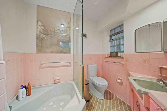 full bathroom featuring vanity, tile patterned floors, toilet, tile walls, and independent shower and bath