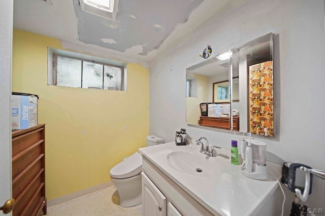 bathroom featuring tile patterned flooring, vanity, and toilet