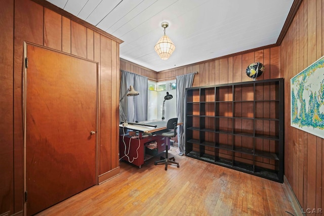 office area featuring light wood-type flooring, ornamental molding, and wood walls