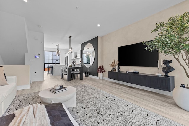 living room featuring a chandelier and light hardwood / wood-style flooring