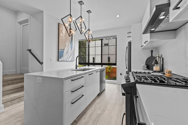 kitchen with white cabinetry, sink, decorative light fixtures, a center island with sink, and appliances with stainless steel finishes