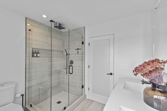 bathroom with walk in shower, toilet, vanity, and hardwood / wood-style flooring