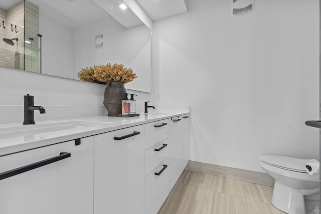 bathroom with vanity, toilet, and a shower with door