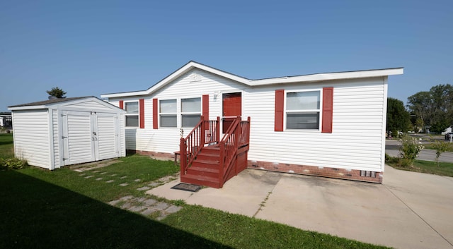 rear view of house with a patio area, a yard, and a storage unit