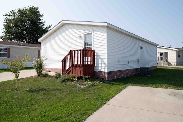 view of home's exterior featuring central AC unit and a yard