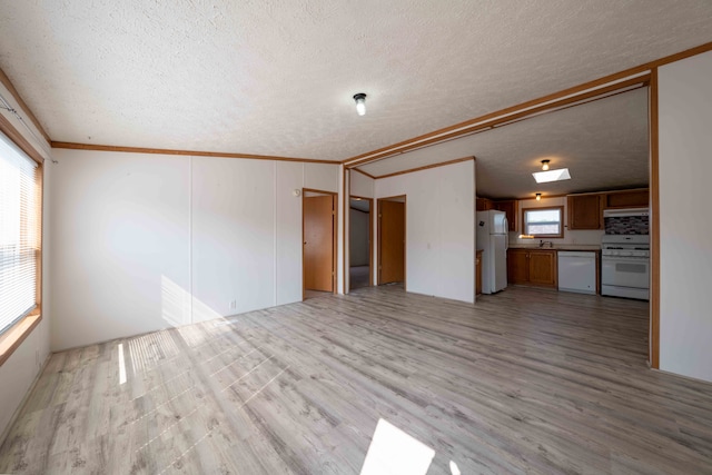 unfurnished living room with ornamental molding, a textured ceiling, and light wood-type flooring