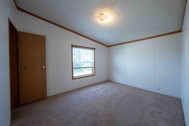 carpeted spare room with crown molding, lofted ceiling, and a textured ceiling