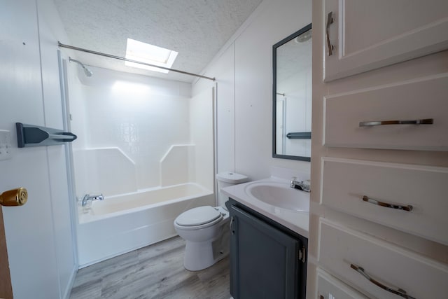 full bathroom with shower / bathing tub combination, vanity, a skylight, a textured ceiling, and wood-type flooring