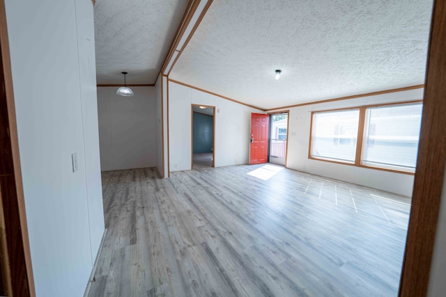 empty room with a textured ceiling, light hardwood / wood-style flooring, and crown molding