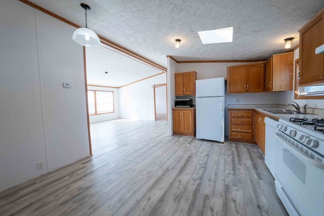 kitchen with crown molding, pendant lighting, white appliances, vaulted ceiling with skylight, and light wood-type flooring