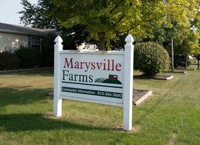 community / neighborhood sign featuring a lawn