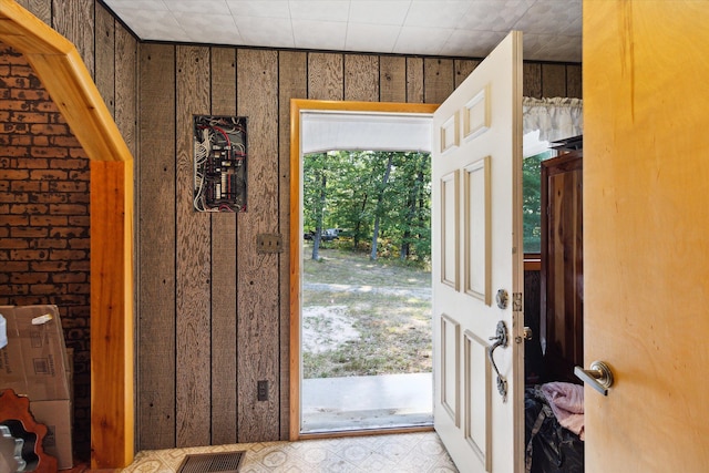 doorway to outside featuring wood walls and plenty of natural light