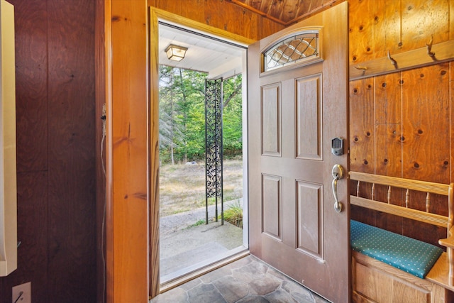 foyer featuring wood ceiling and wooden walls