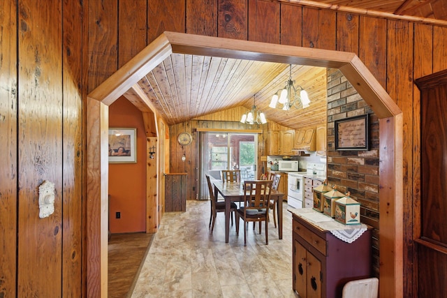 dining space with wood walls, lofted ceiling, wooden ceiling, an inviting chandelier, and light wood-type flooring