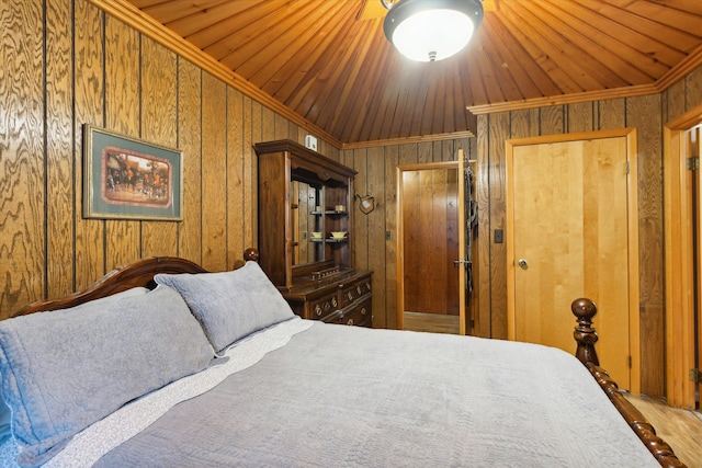 bedroom with wood walls, crown molding, wood-type flooring, and vaulted ceiling