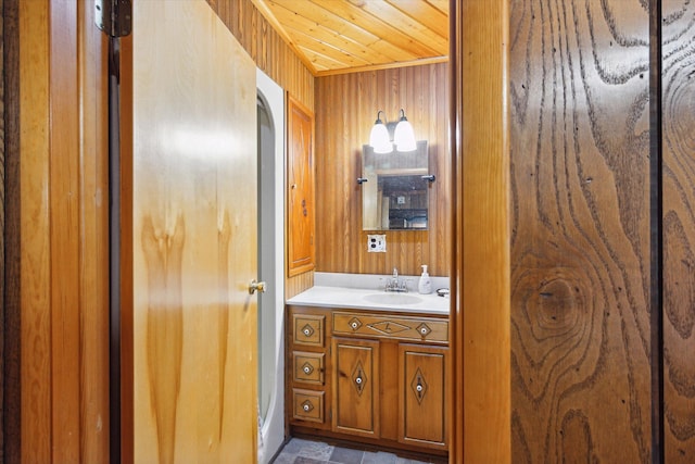 bathroom featuring vanity, wooden ceiling, and wooden walls