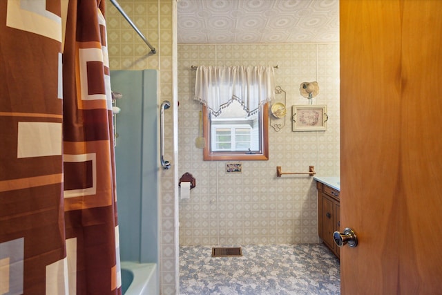 bathroom with tile walls, vanity, and shower / bath combo