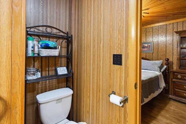 bathroom with hardwood / wood-style floors, toilet, and wood walls