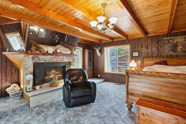 carpeted bedroom with wooden walls, a fireplace, beam ceiling, wood ceiling, and a chandelier