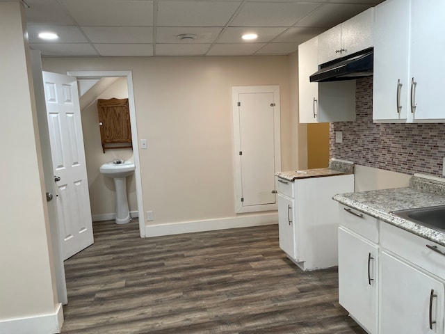 kitchen with dark hardwood / wood-style flooring, white cabinetry, a drop ceiling, and sink