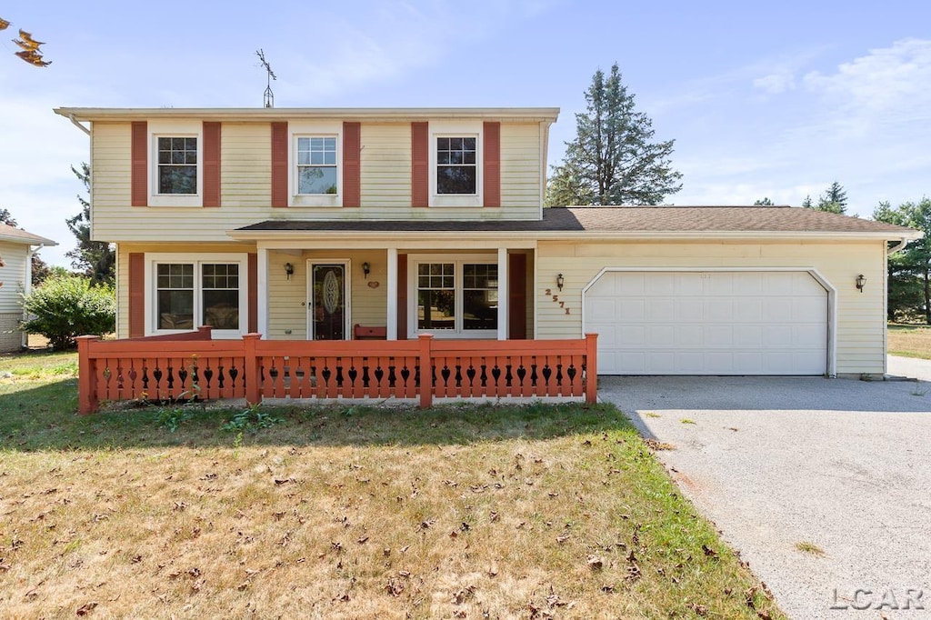 front of property with a garage and a front lawn