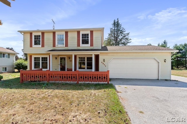 view of front property with a front lawn, covered porch, and a garage