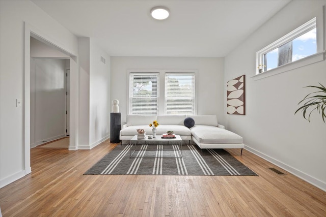 sitting room featuring hardwood / wood-style flooring and a healthy amount of sunlight