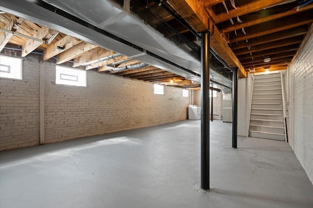 basement with washer / clothes dryer and brick wall